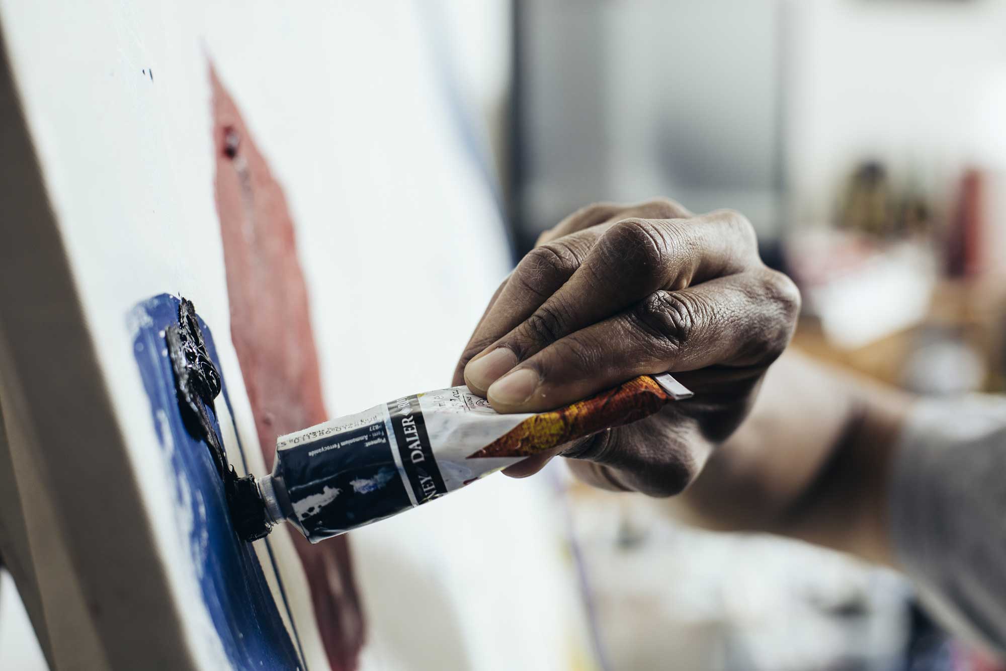 Artist using blue paint from a tube